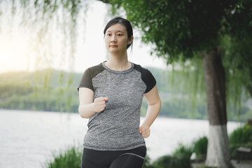 Young Woman Enjoying a Peaceful Run in Lush Park