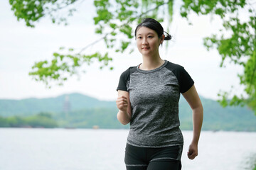 Young Woman Enjoying a Peaceful Run by the Lake