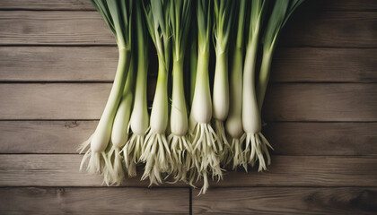 Obraz premium Bunch of freshly picked leeks standing on wooden table. 