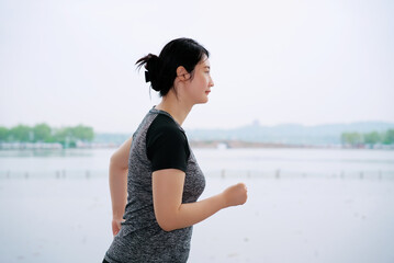 Young Woman Enjoys Morning Jog by the Lake