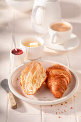Homemade and sweet french croissants with jam and butter.
