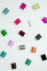 Multicolored sewing threads on white background