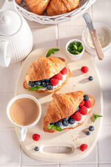 Sweet and hot french croissant with berries and cottage cheese.