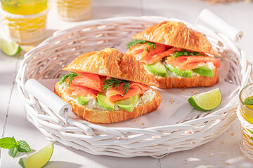 Tasty and hot french croissant with salmon and avocado