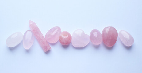 Pink healing chakra rose quartz crystals. The stones are laid out in the shape of a line. Real...