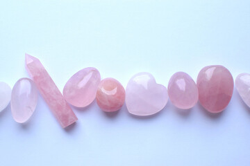 Pink healing chakra rose quartz crystals. The stones are laid out in the shape of a line. Real...