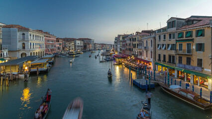 Grand Canal in Venice, Italy day to night timelapse. Gondolas and city lights from Rialto Bridge.