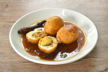 fried egg half cut dressing sweet tamarind sauce topping chili on plate