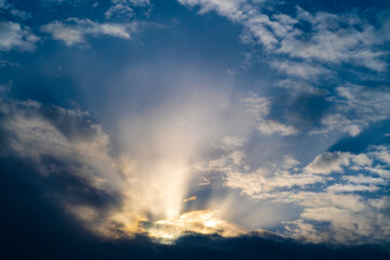 Obraz premium Background with a dramatic sky and sun rays from behind the clouds.