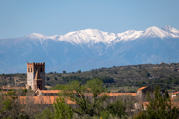 he clovher of Espira de l'Agly in front of the snow-covered Canigou

