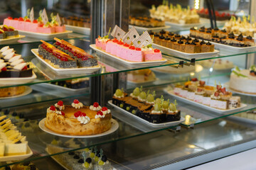 Showcase with sweets, Various desserts and cakes for sale in the pastry shop. Glass display at store bakery pastry shop.