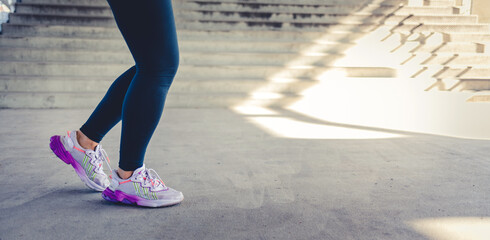 Runner athlete, woman and feet on pavement with blurred background ready for fitness and exercise. Road, run shoes and training of a female person outdoor for sports, race and marathon.