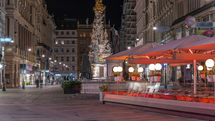 Obraz premium People is walking in Graben St. night timelapse, old town main street of Vienna, Austria.