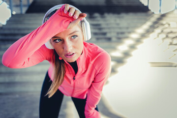 City fitness, happy woman and music earphones for training, motivation and exercise in urban city. Sports athlete, runner and healthy person listening to audio for cardio running workout