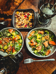 Fresh salad plate with shrimp, tomato, spinach, cabbage and Tangerine Jam and vegetarian salad with beets, spinach, orange, tofu in plate on wooden table background