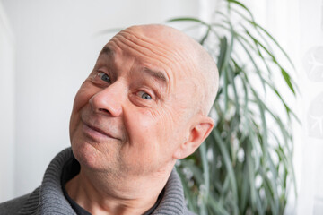 65-year-old eccentric man, senior showing grimaces, winks, mischievous grin, embracing life's...