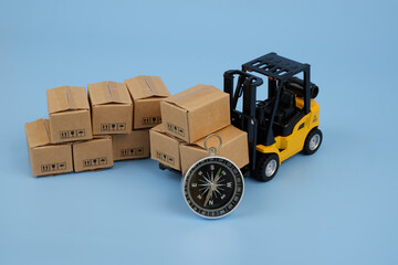 Forklift truck with many carton boxes and compass on blue background. Logistics and cargo concept.