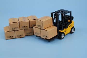 Many carton boxes and yellow forklift track. Delivery and cargo concept. 