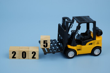 Forklift truck arranging wooden cubes with numbers 2025 on blue background.