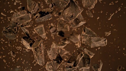 Freeze motion of flying group of raw chocolate pieces.