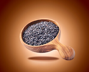 Black Sesame seeds in wooden spoon isolated on white background