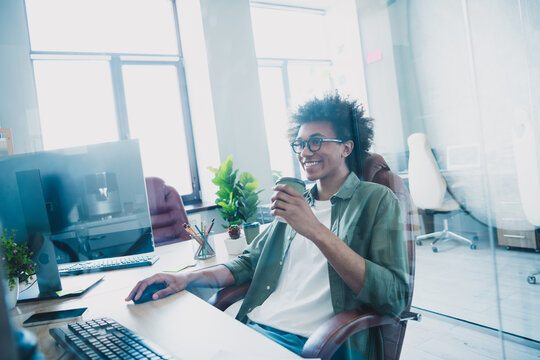 Photo of handsome cool assistant dressed khaki shirt glasses drinking tea working modern gadget indoors workstation workplace