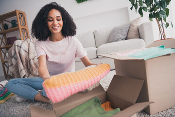 Photo of lovely cute girl wearing trendy clothes sitting floor packing parcel package preparing relocation indoors