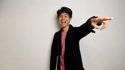 Handsome young Asian man wearing cool clothes pointing forward