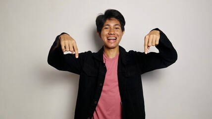 Excited young handsome Asian man wearing cool clothes posing pointing upwards