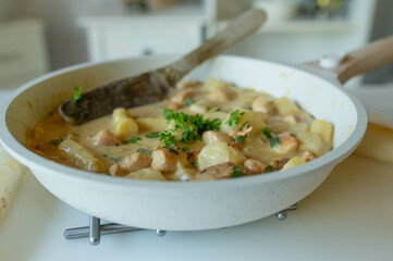 Creamy chicken fillet with white asparagus in a frying pan ready to eat