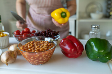 Ingredients on a cutting board for cooking a healthy bean soup with kidney beans, baked beans and vegetables