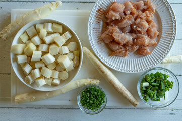 Food background with chopped white asparagus, chicken breast and herbs for cooking a healthy meal