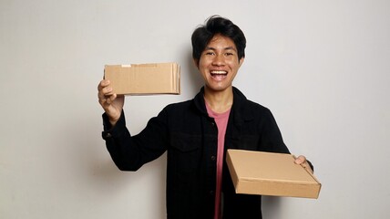excited young asian man holding parcel box package. Delivery courier and shipping service concept