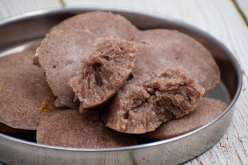 Red millet idlis- traditional south Indian steamed cakes made with fermented millet batter. Served with sambar, rasam and other side dishes.