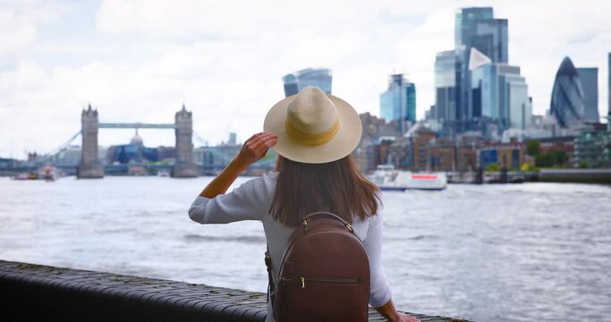 A tourist woman on a city vacation trip looks at the skyline of London, England