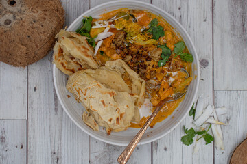 Vegan Indian korma made with seitan and coconut cream, served with paratha flat breads.