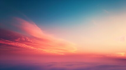 Fototapeta premium A serene sky painted with a gradient of orange and blue hues as the sun sets, with soft clouds.