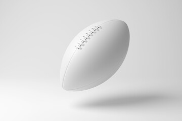 White American football floating in mid air on white background in monochrome and minimalism. Illustration of the concept of sports leagues, team games and competition