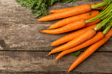 Carrots on a textured wooden background. Fresh and sweet organic carrots on a white background. Carrot slices. Vegan. Ingredients for salad. Place for text. Copy space. Flatley