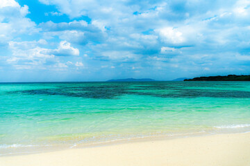 沖縄県竹富島まぶしい砂浜、青い空、透き通る緑の海