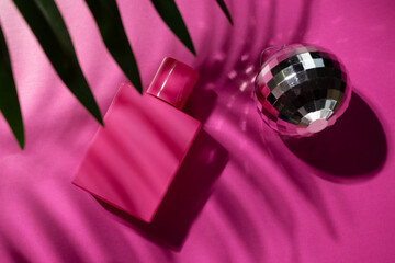 Rose perfume with palm leaf and disco ball on pink background, sensual aroma, essential liquid, glamorous fragrance