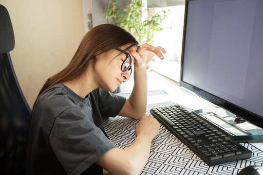 Teenager has headache, tired from study, slouched at desk with textbooks open