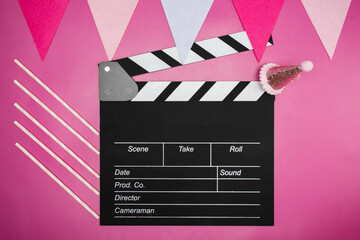 Cinema clapper board and birthday decorations, festive atmosphere, party hats and colorful streamers