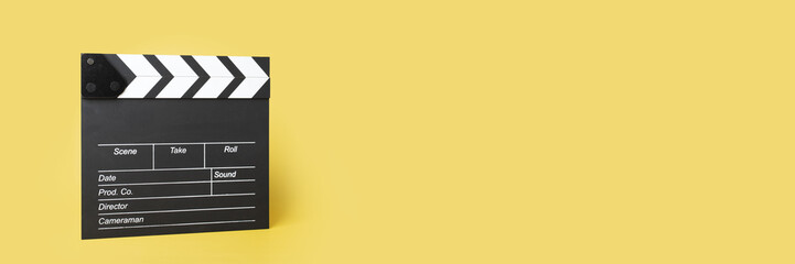 Obraz premium Cinema clapper board on a yellow background, copy space, movie-making instrument, capturing the moment, cinematic artistry,banner