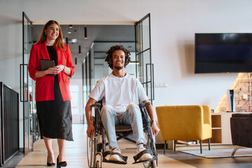 A business leader with her colleague, an African-American businessman who is a disabled person,...