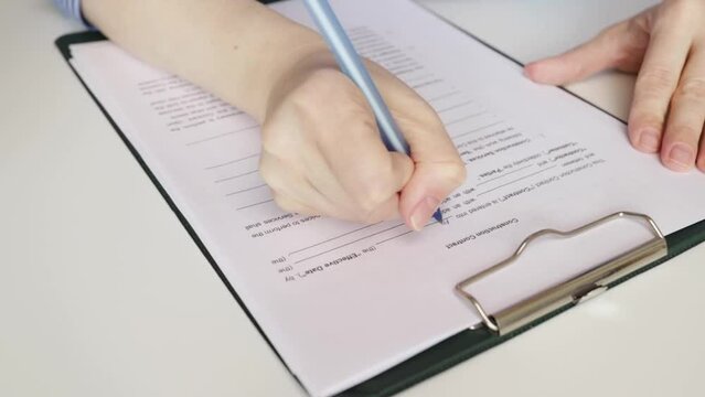 Construction contract, hand fills out a document, architect finalizing project details, contractor reviewing agreement terms