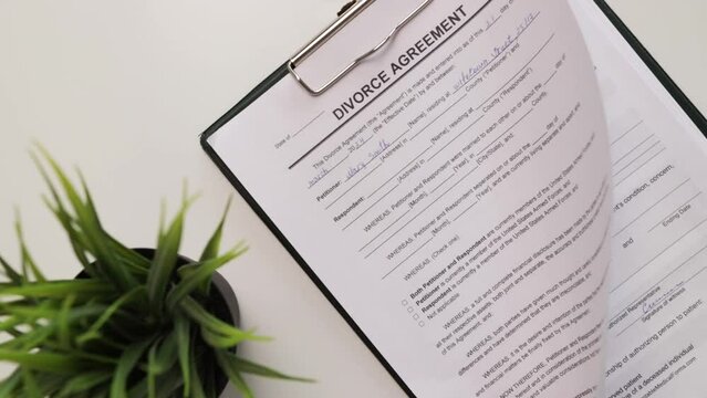 Divorce agreement, hand fills out a document, signing the contract, ending the marriage, verdict paperwork, marriage dissolution