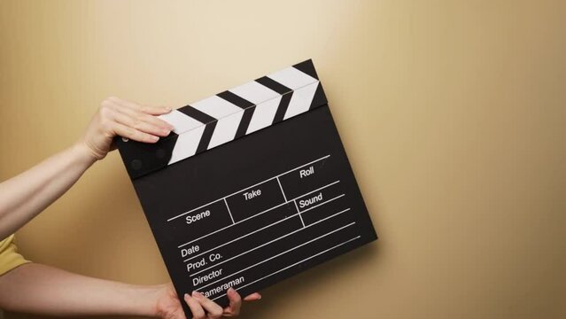 hands with cinema clapper board, production assistant preparing for scene, director's tool in action