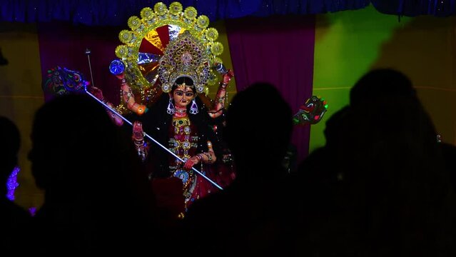 silhouette of people with goddess durga sculpture