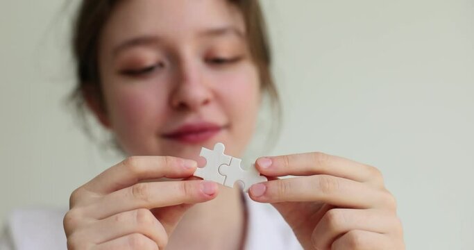 Connecting jigsaw puzzle business solution woman connects jigsaw puzzle. Success and strategy concept connecting pair of puzzle pieces
